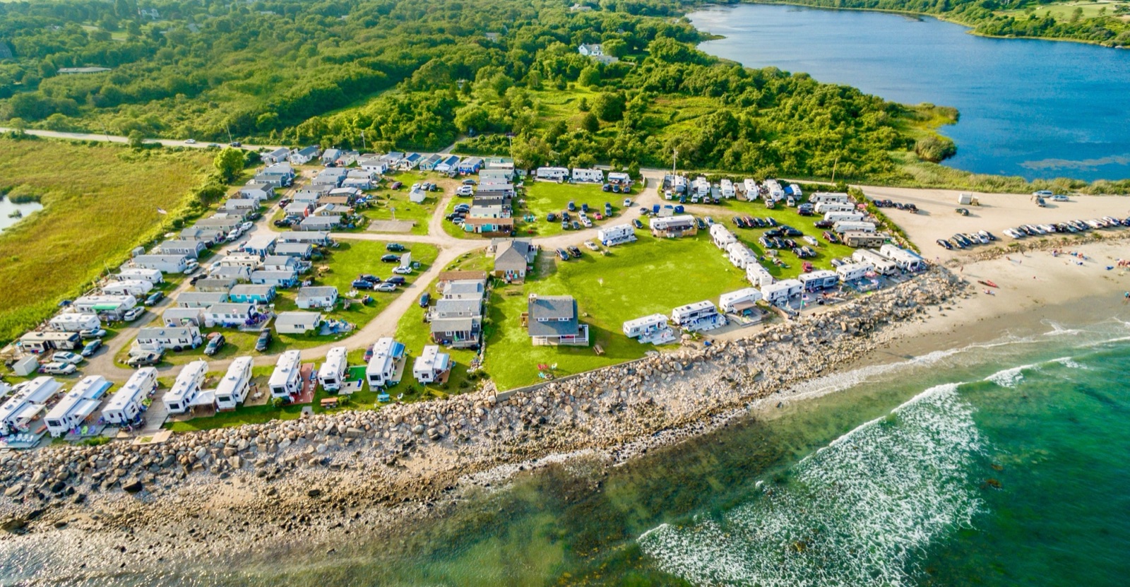 Aerial view of an oceanfront RV resort beside a lagoon
